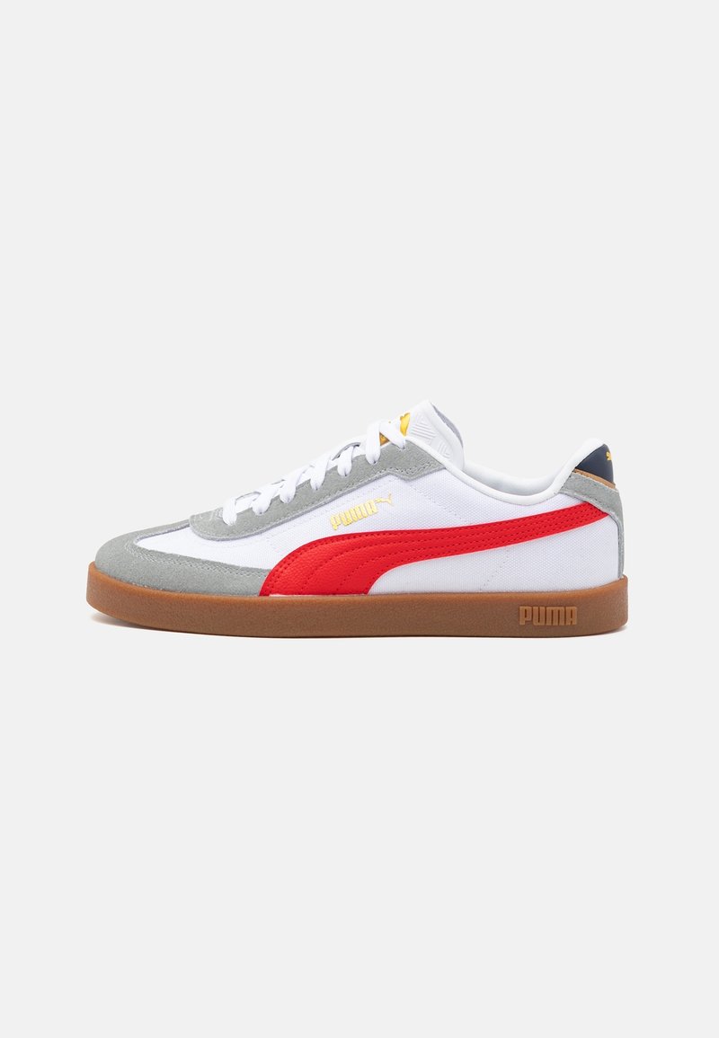 Baskets basses blanches et grises avec bande rouge Puma, semelle en gomme, lacets blancs et logo Puma doré sur le côté et la semelle.
