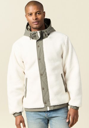 White fleece jacket with a khaki hood and accents. Features zip closure, snap buttons, side pockets, and elastic cuffs. Soft texture.