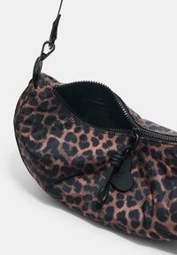 Borsa con stampa leopardata in tessuto nero e marrone, dotata di chiusura con zip, tasca interna e una tracolla nera con attacco a gancio.