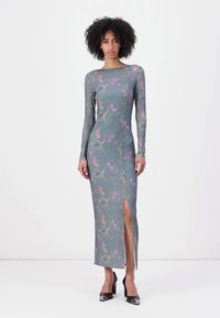 Long-sleeve, form-fitting dress in green with purple and pink floral patterns, featuring a side slit and smooth, stretchy material.