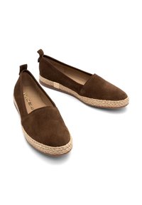 Brown suede flats with a rounded toe, woven jute midsole, and small heel. Features a tab at the back for easy wear.