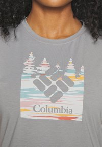 Grå bomullströja med en färgglad grafik av träd och vatten, med en central logo "Columbia" i fetstil.