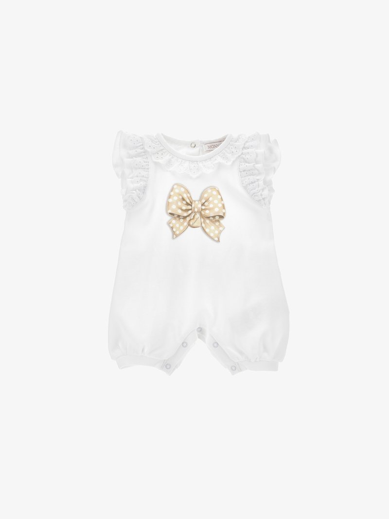 Witte baby romper met korte rimpelende mouwen, kantafwerking en een grote beige stippen strik aan de voorkant. Drukknopen aan de onderkant.