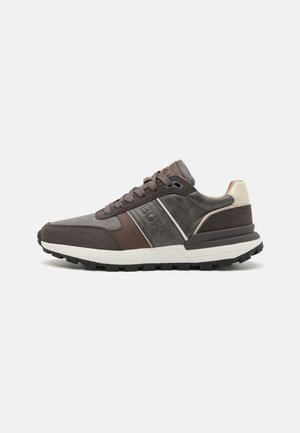 Donkerbruine sneakers van suède en leer, met een versterkte neus, klassieke veters en een geprofileerde rubberen zool voor grip.