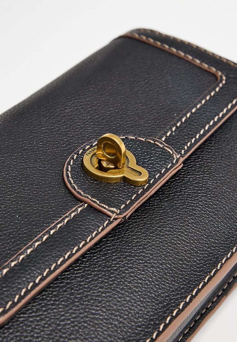 Portefeuille en cuir noir avec une finition texturée. Il présente des coutures contrastantes en tan et un fermoir en métal doré d'une forme unique.