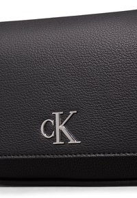 Portafoglio in pelle nera texturizzata con logo cK argentato. Presenta un design elegante e cuciture a contrasto lungo i bordi.