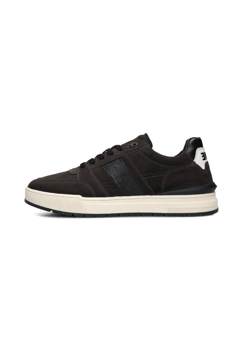 Zwarte suède sneaker met een witte zool, voorzien van een getextureerde zwarte leren accent en logo, ronde neus en platte veters.