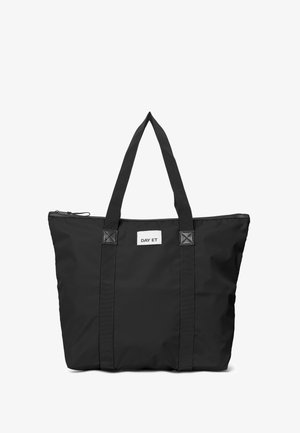 Black tote bag with two sturdy handles and a zippered top, featuring a small white label with "DAY ET" on the front.