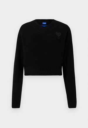 Black cropped sweater with a V-neck, ribbed hem, and long sleeves. Features a small textured heart detail on the chest. Made of soft material.