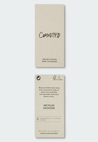 Etichetta per abbigliamento sostenibile realizzata in carta riciclata beige. Fronte con la scritta "Impegnato" in grassetto nero; retro con informazioni sul trattamento e loghi.