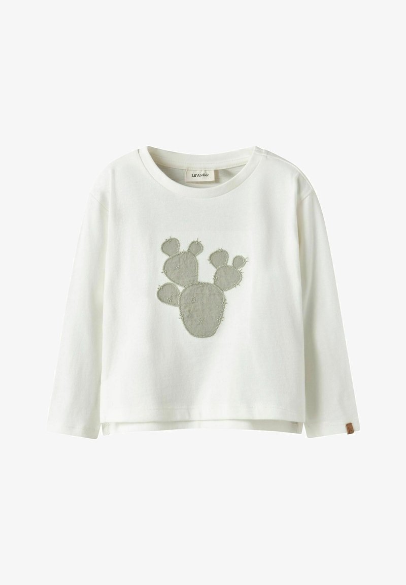 Chemise blanche à manches longues en coton avec un appliqué de cactus gris sur le devant. Comprend un col rond et une petite étiquette sur le côté.