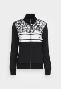 Chaqueta negra con cremallera y sección superior con estampado de cebra, franjas blancas en el pecho y el logo de Fila en rojo. Tela suave, diseño deportivo.