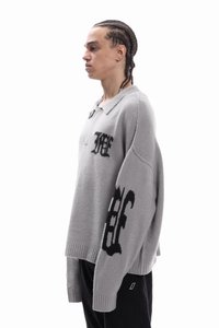 Grijze gebreide trui met kraag, voorzien van zwarte logo-ontwerpen en een losse pasvorm. Geribbelde manchetten en zoom accentueren de relaxte stijl.