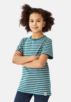 Stribet t-shirt i turkis og grå med korte ærmer, rund halsudskæring og et vævet mærke ved sømmen. Kombineret med mørke jeans.