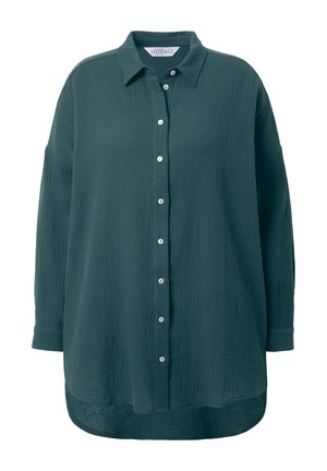 Chemise oversize vert foncé à boutons, en tissu texturé, avec un col, des manches longues et des boutons blancs visibles sur le devant.