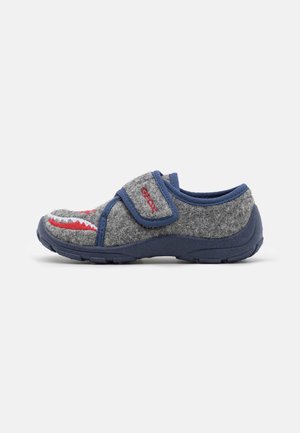 Chausson enfant gris et marine avec un motif requin, fermeture Velcro et semelle texturée sur fond clair uni.
