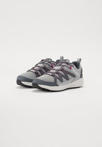 Gray athletic shoes with pink accents; mesh upper, textured rubber sole, and reinforced heel. Laces feature elastic for a secure fit.