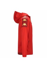 Giacca con cappuccio rosso realizzata in tessuto liscio. Presenta accenti dorati del logo e tre toppe con emblema dorato sulla spalla. Inclusi taschini laterali con zip.