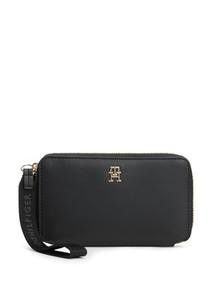 Schwarzes Lederhandgelenkportemonnaie mit goldfarbenem Tommy Hilfiger-Logo und schwarzem Stoffriemen mit Prägung "HILFIGER", Reißverschlussverschluss.
