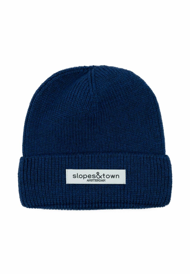 Cappello di lana blu navy con risvolto. Presenta un'etichetta rettangolare con "slopes&town" e "AMSTERDAM" in testo nero su uno sfondo bianco.