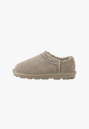 Beige Veloursleder-Hausschuh zum Hineinschlüpfen mit weichem Fellfutter und strukturierter Gummisohle, entworfen für Komfort und Wärme im Innenbereich.