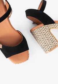 Sandalias de tacón alto de ante negro con plataforma de rafia trenzada y plantilla de cuero marrón. Presenta un diseño de tiras entrelazadas.
