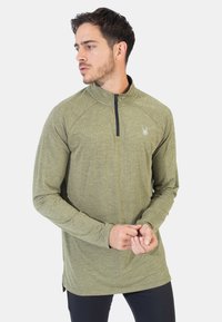 Jersey de color verde oliva con media cremallera y mangas largas. Presenta una tela texturizada y un pequeño logo en el pecho.