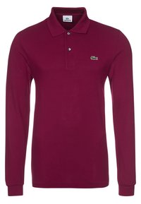 Camisa polo de manga larga en burdeos, fabricada con tejido texturizado. Presenta un cierre de dos botones y un logo bordado en verde en el pecho.