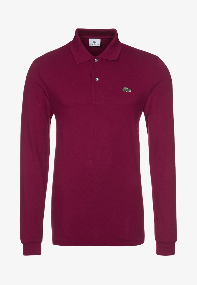 Camisa polo de manga larga en burdeos, fabricada con tejido texturizado. Presenta un cierre de dos botones y un logo bordado en verde en el pecho.
