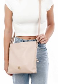 Borsa a tracolla in pelle rosa chiaro con design elegante e minimalista, tracolla regolabile e accentuazione del logo in tonalità oro.