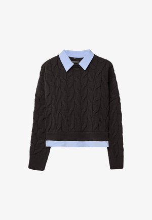 Črni pulover iz kabelskega pletenja s svetlo modro srajco pod njim, ki se ponaša s krajšo dolžino in rebrastim robom ter manšetami za dodano teksturo.