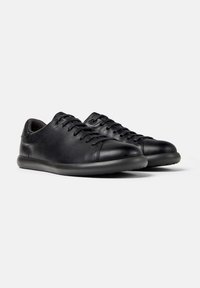 Pair of black leather low-top sneakers with black laces and rounded rubber soles on a white background.
