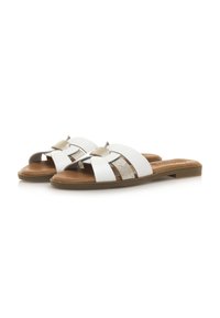 Sandalias deslizantes blancas con acentos dorados, con tiras en forma de crisscross y suela plana. Textura suave con forma curva y diseño de punta abierta.