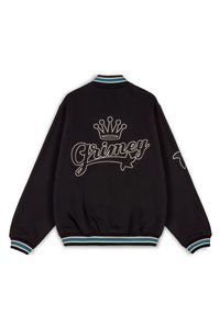 Chaqueta varsity negra con un logo bordado y detalle de corona en la parte trasera. Puños y dobladillo acanalados con rayas en teal y blanco.