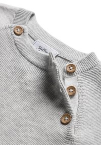 Maglione grigio chiaro lavorato a maglia con bottoni in legno e colletto a coste, parzialmente sbottonato, che mostra un'etichetta bianca del marchio all'interno del collo.