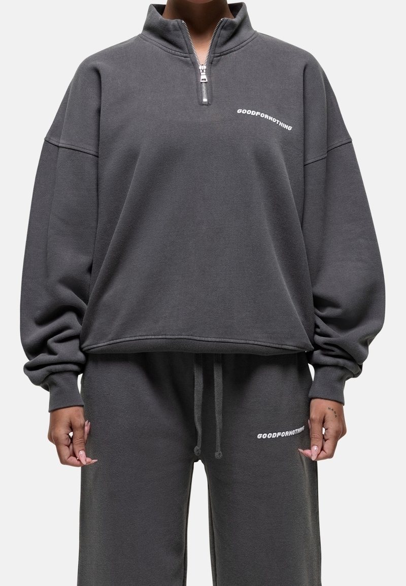 Pullover grigio con colletto a mezza zip, vestibilità ampia e logo in bianco. Materiale misto cotone, polsini e cintura a costine.