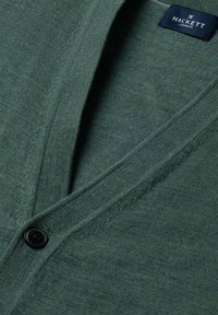 Zielony kardigan z dekoltem w kształcie litery V, czarnym guzikiem i metką Hackett London na kołnierzu, ukazujący drobną strukturę dzianiny i szczegóły szwów.