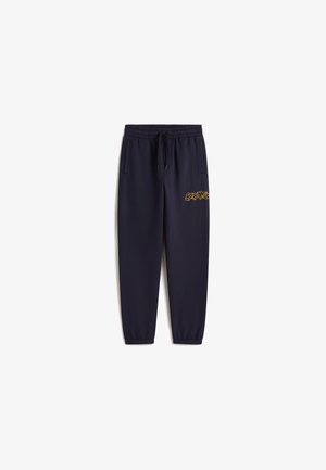 Pantalones deportivos azul marino con cintura elástica, cordón, dos bolsillos laterales y detalle del logo amarillo en el muslo izquierdo. Puños elásticos en los tobillos.