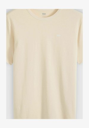Beige T-shirt med korte ærmer og rund hals, med lille Levi's-logo på venstre bryst, vist på ensfarvet baggrund.