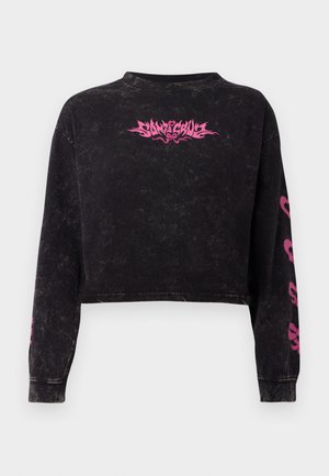 Svart kortermet hettegenser med teksturert overflate. Har et sentralt rosa grafikk og rosa design langs begge ermer.