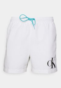 Shorts de bain blancs avec une taille élastique, cordon turquoise et logo "CK" noir en bas à gauche. Texture lisse et design décontracté.