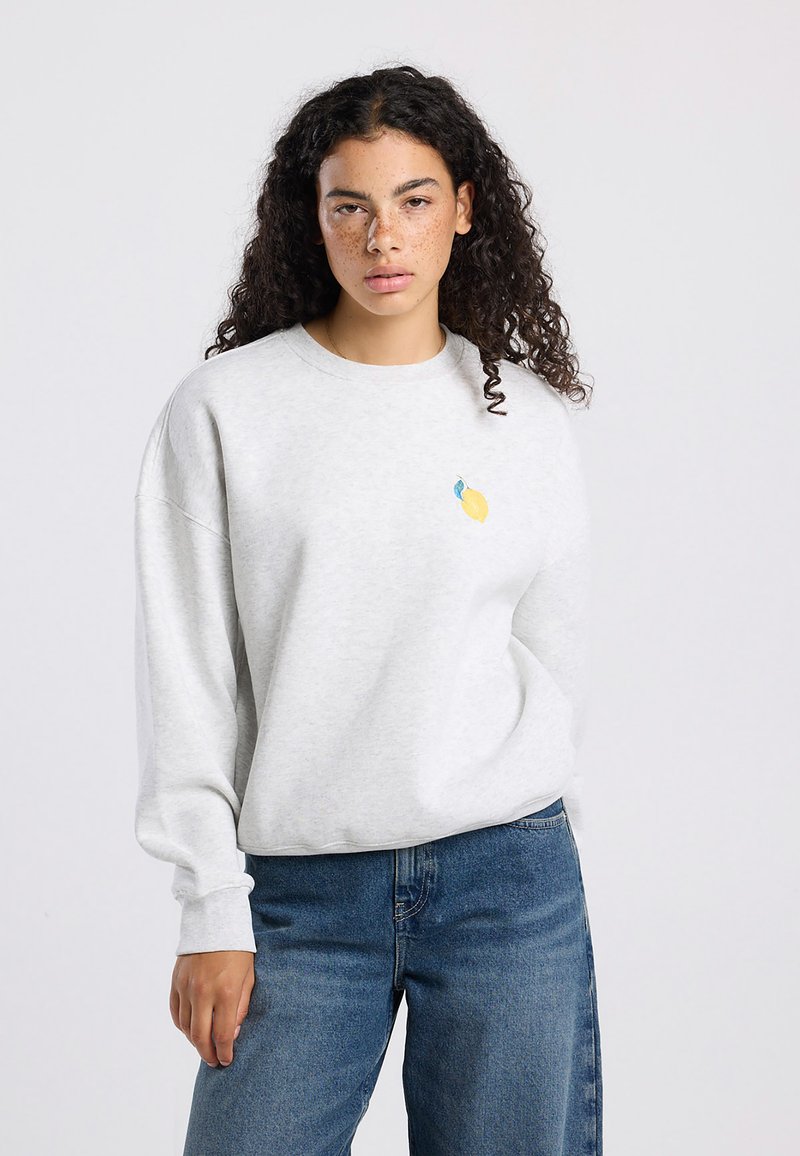 Light gray sweatshirt in soft cotton blend, featuring a small yellow and blue lemon graphic on the chest. Relaxed fit with long sleeves.