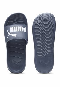 Tamsiai mėlynos šlepetės su tekstūruota pado ir dirželio dalimi. Savybė - išryškintas baltas "PUMA" logotipas ir tekstūruota išorinio pado struktūra.