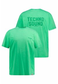 Camiseta de algodón verde con cuello redondo. En el frente cuenta con una impresión pequeña; en la parte posterior tiene un gran texto que dice "MUNDO DEL SONIDO TECNOLÓGICO". Textura suave.