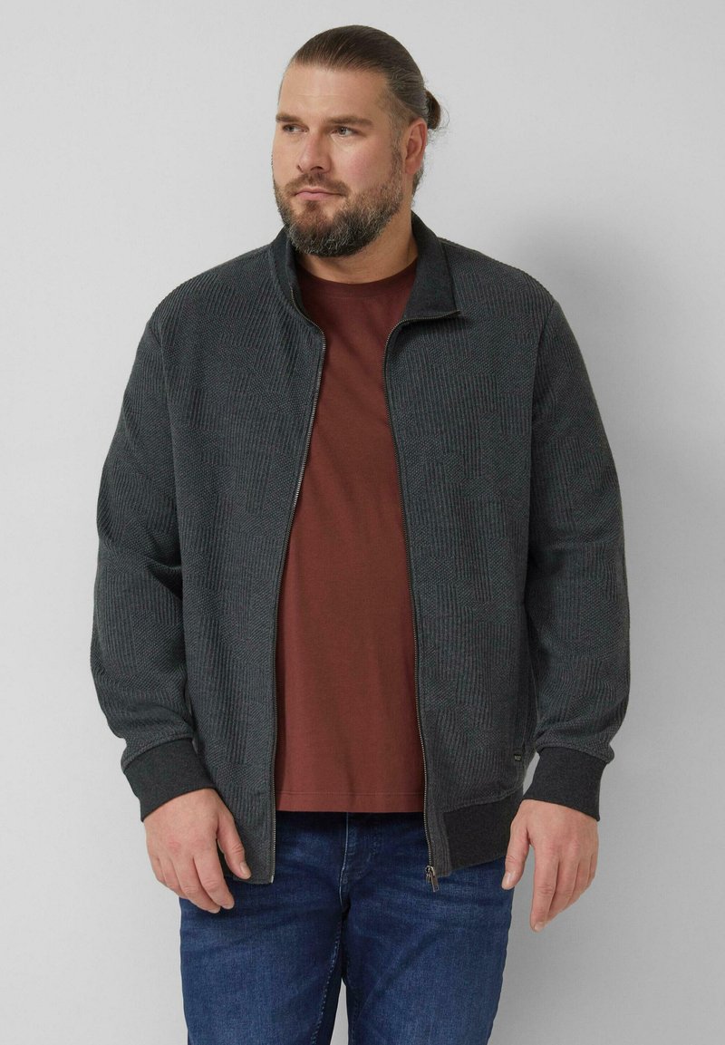 Dark gray zipped jacket with a textured pattern, featuring a stand-up collar and ribbed cuffs, layered over a maroon shirt.