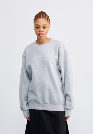 Sweatshirt gris à manches longues, avec des bords-côtes aux poignets et à l'ourlet, présentant un petit logo blanc sur la poitrine. Tissu en coton lisse et coupe décontractée.