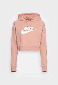 Rosa kort hoodie gjord av mjukt tyg, med en rymlig huva, dragsko och en vit Nike-logotyp över framsidan.