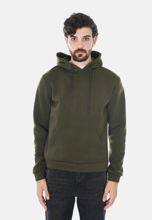 Felpa con cappuccio verde oliva con tasca frontale, coulisse regolabili e polsini a coste, realizzata in un tessuto morbido, abbinata a jeans scuri.