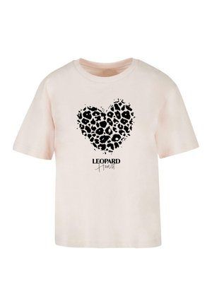 Bāla rozā kokvilnas T-krekls ar melnu leopardu printu sirdī un tekstu "LEOPARD Heart" zem tā, rakstītā svītro fontā.