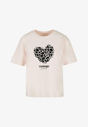 Tricou din bumbac de culoare roz pal, cu un design de inimă din imprimeu de leopard negru și textul „LEOPARD Heart” scris cu un font în stil caligrafic dedesubt.